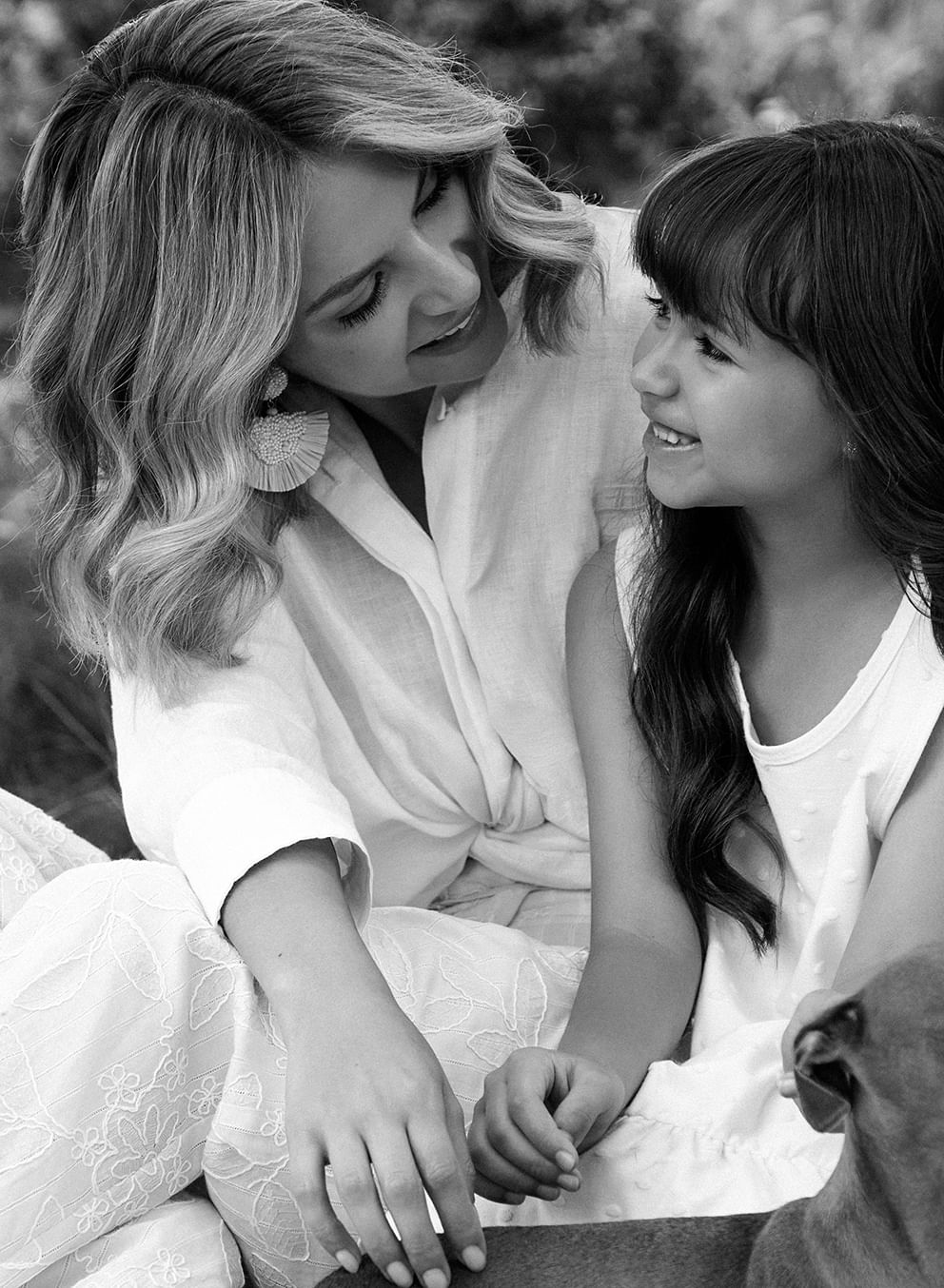Foto en plano detalle de mujer usando blusa mujer en color blanco junto a su hija