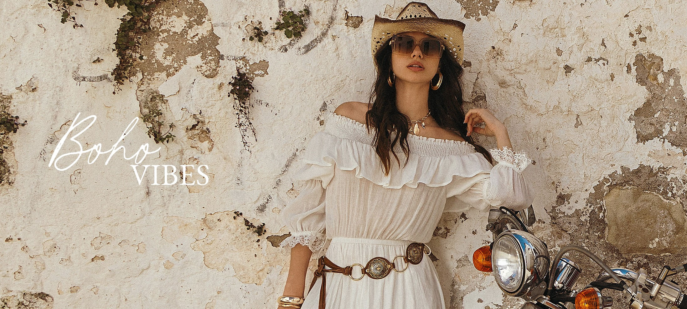 Modelo mujer usando vestido blanco de manga 3/4 y cuello bandeja con boleros, sombrero y gafas de la marca Studio F